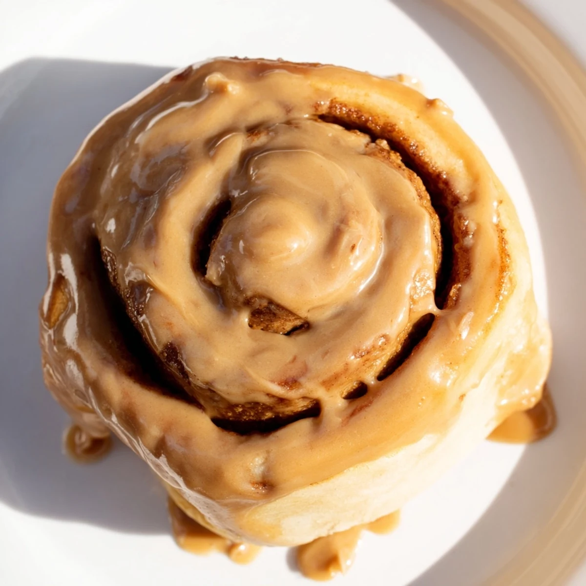 Freshly baked Soft and Gooey Biscoff Cinnamon Rolls served with a cup of coffee on the side.