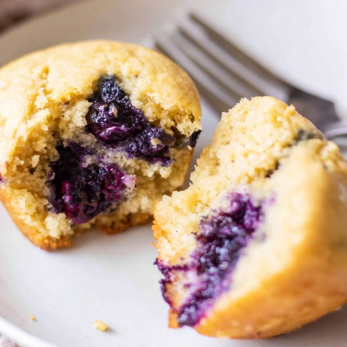 Overhead view of Blueberry Protein Muffins with Greek Yogurt in a muffin tin, topped with coarse sugar and ready to be enjoyed for breakfast.