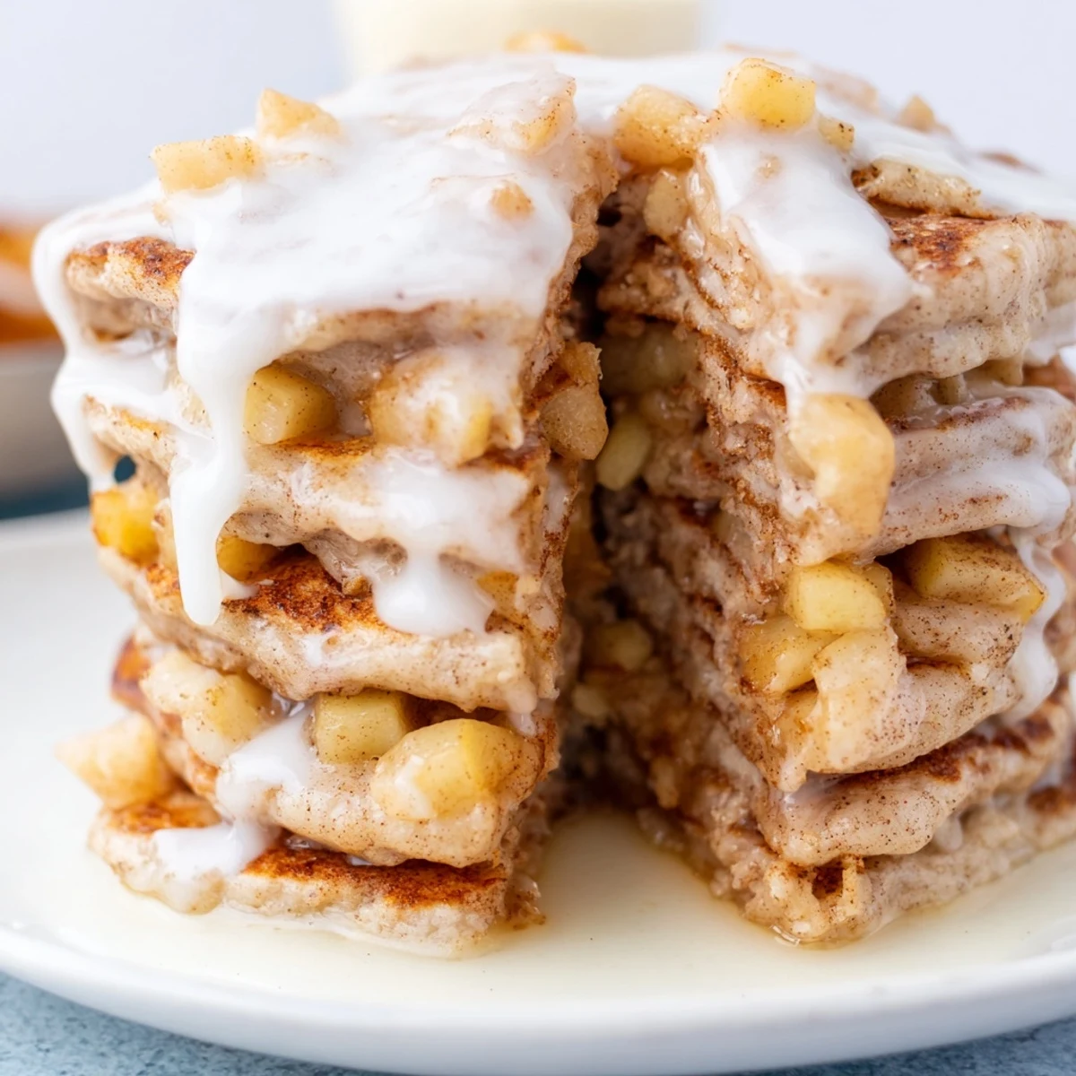 A close-up view of Apple Fritter Pancakes, showing the moist crumb, diced apples, and a shiny cinnamon-sugar glaze on top.