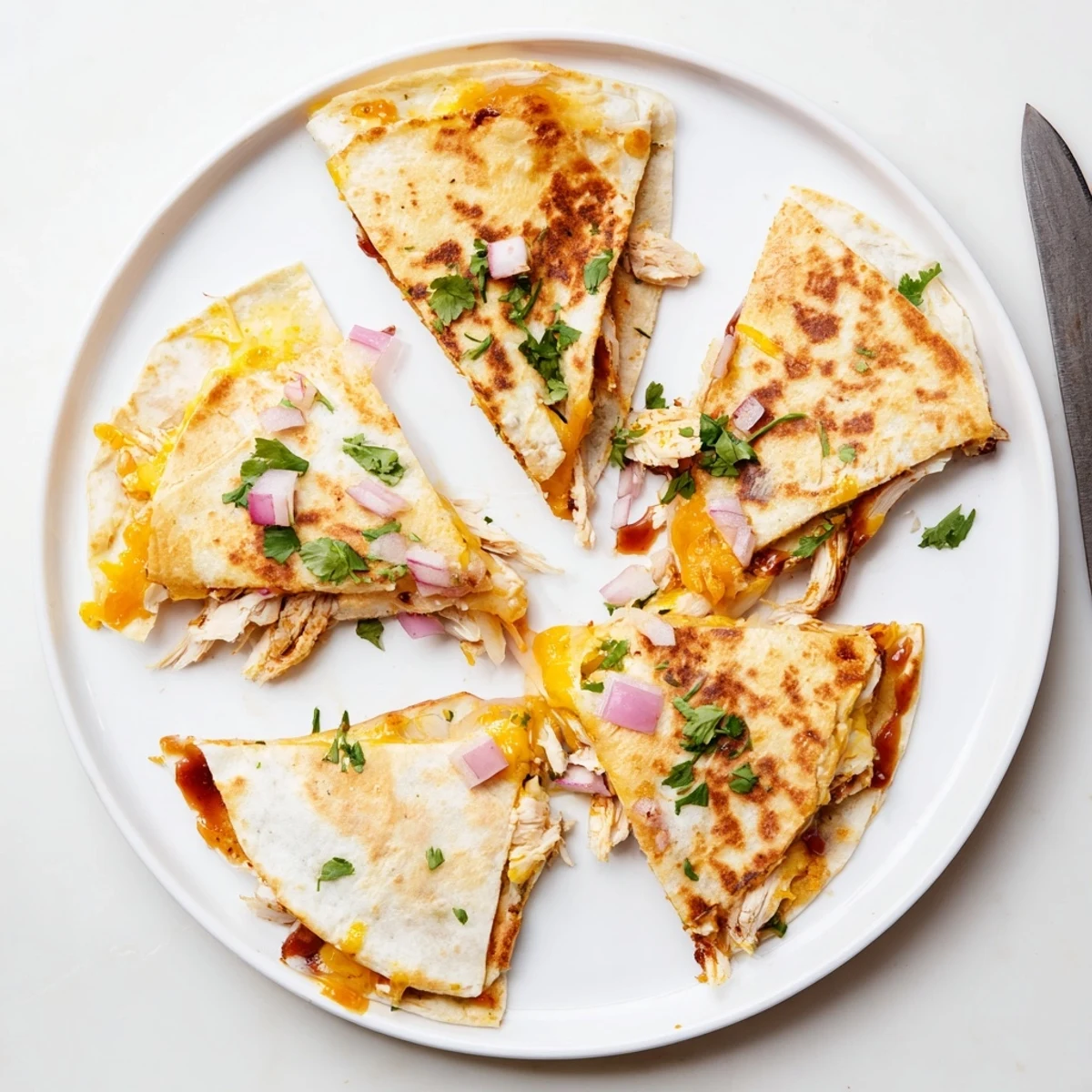 Golden-brown Hot Honey BBQ Chicken Quesadillas sizzling in a skillet, showing melted cheese oozing from the crispy tortilla edges.