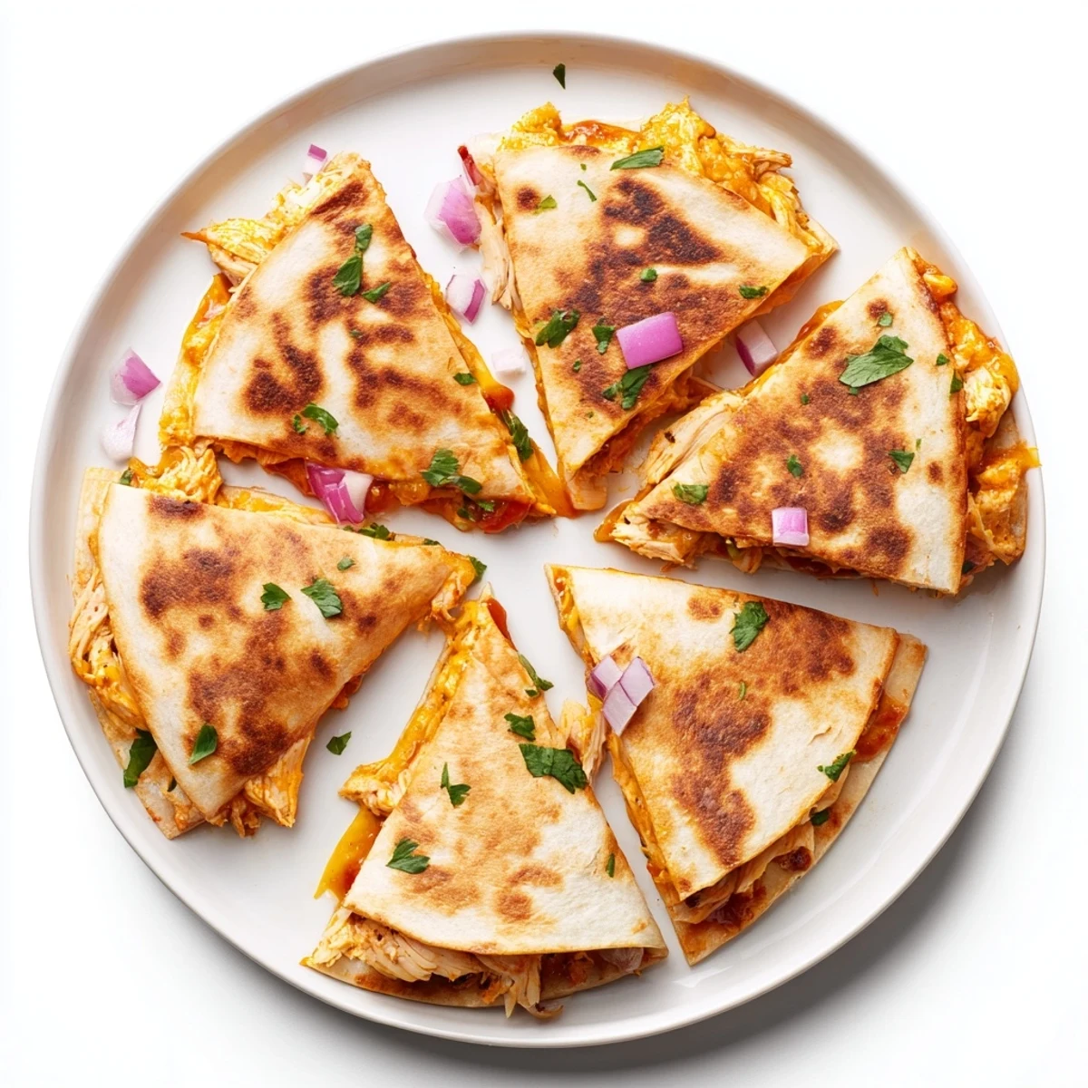 Close-up view of Hot Honey BBQ Chicken Quesadillas highlighting the shredded chicken and red onion filling inside the golden crust.