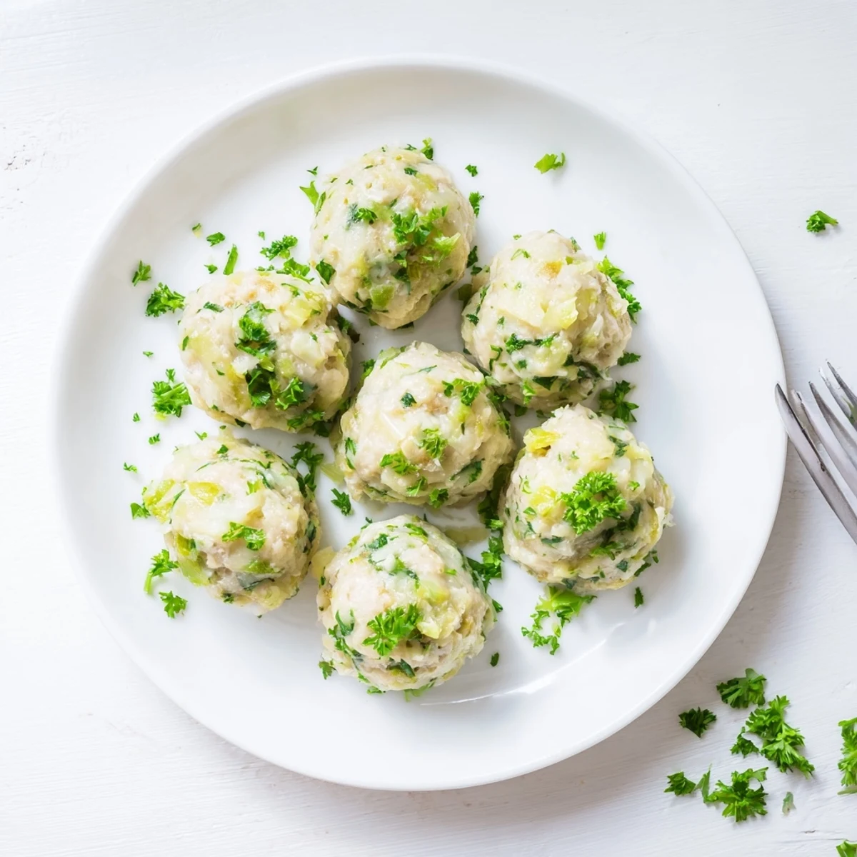 Eight tender German Cabbage Dumplings simmer in vegetable broth, served fresh with parsley garnish.