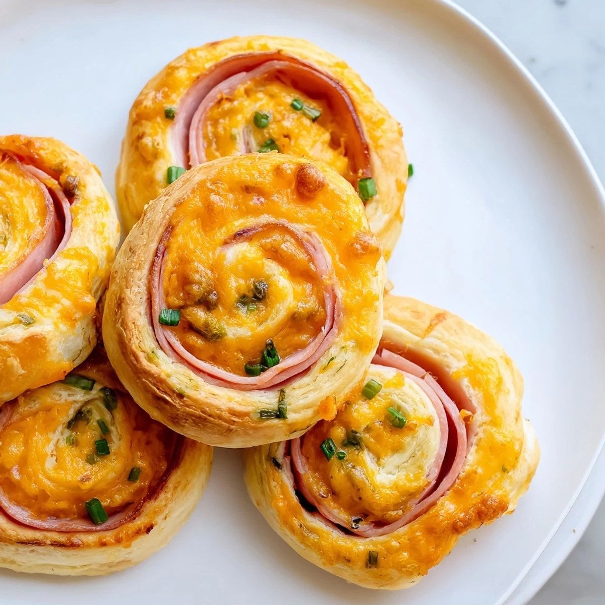 Close up of savory Easter ham Cheddar pinwheels featuring layers of ham and melted cheddar