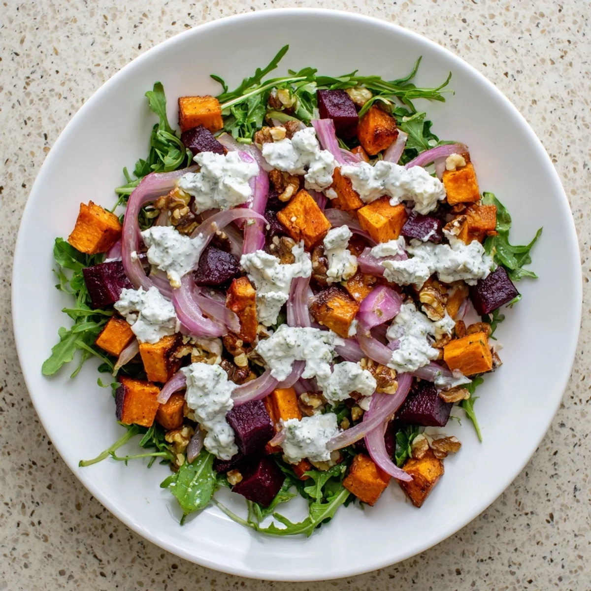Creamy roasted beet salad featuring golden sweet potatoes, tangy feta cheese, and luscious yogurt dressing