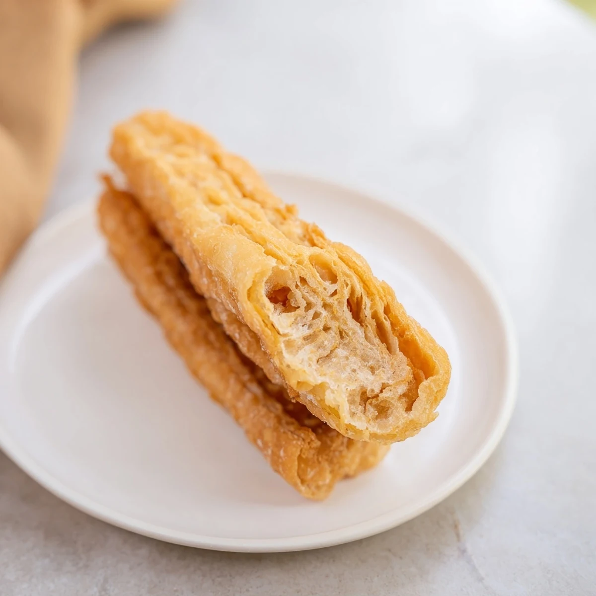 Golden fried Youtiao Chinese breakfast doughnuts with crispy exterior and soft hollow interior