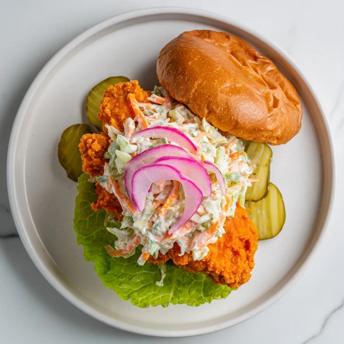 Spicy fried buffalo chicken breast layered with creamy ranch coleslaw on soft toasted sandwich bun
