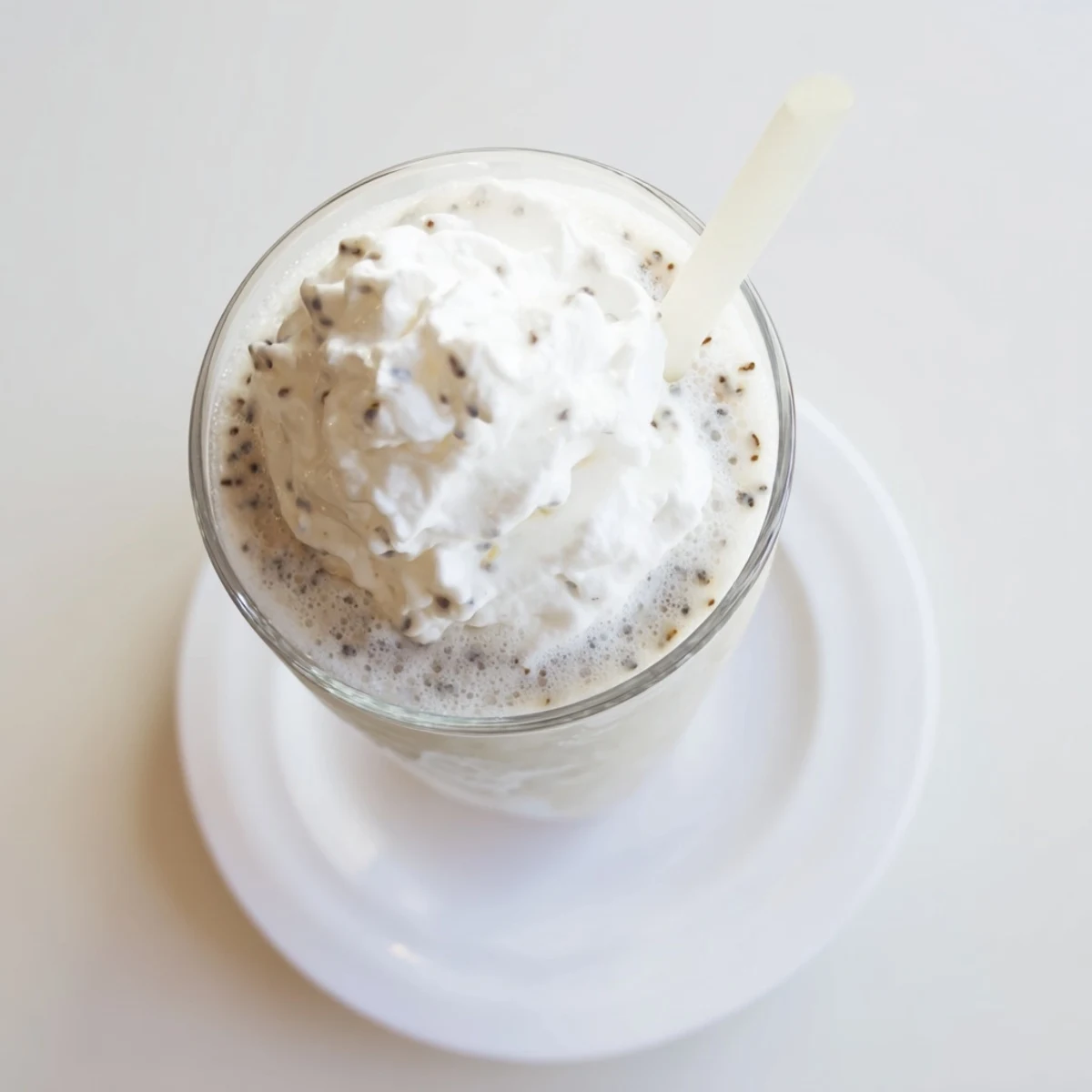 Creamy vanilla bean frappuccino topped with fluffy whipped cream in a chilled glass