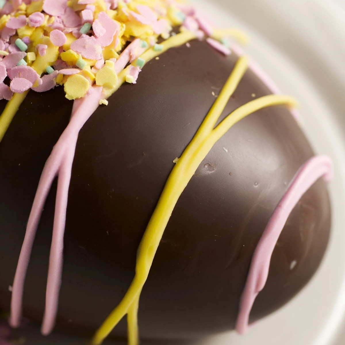 Creamy Cool Whip Easter Eggs dipped in smooth chocolate topped with colorful pastel sprinkles