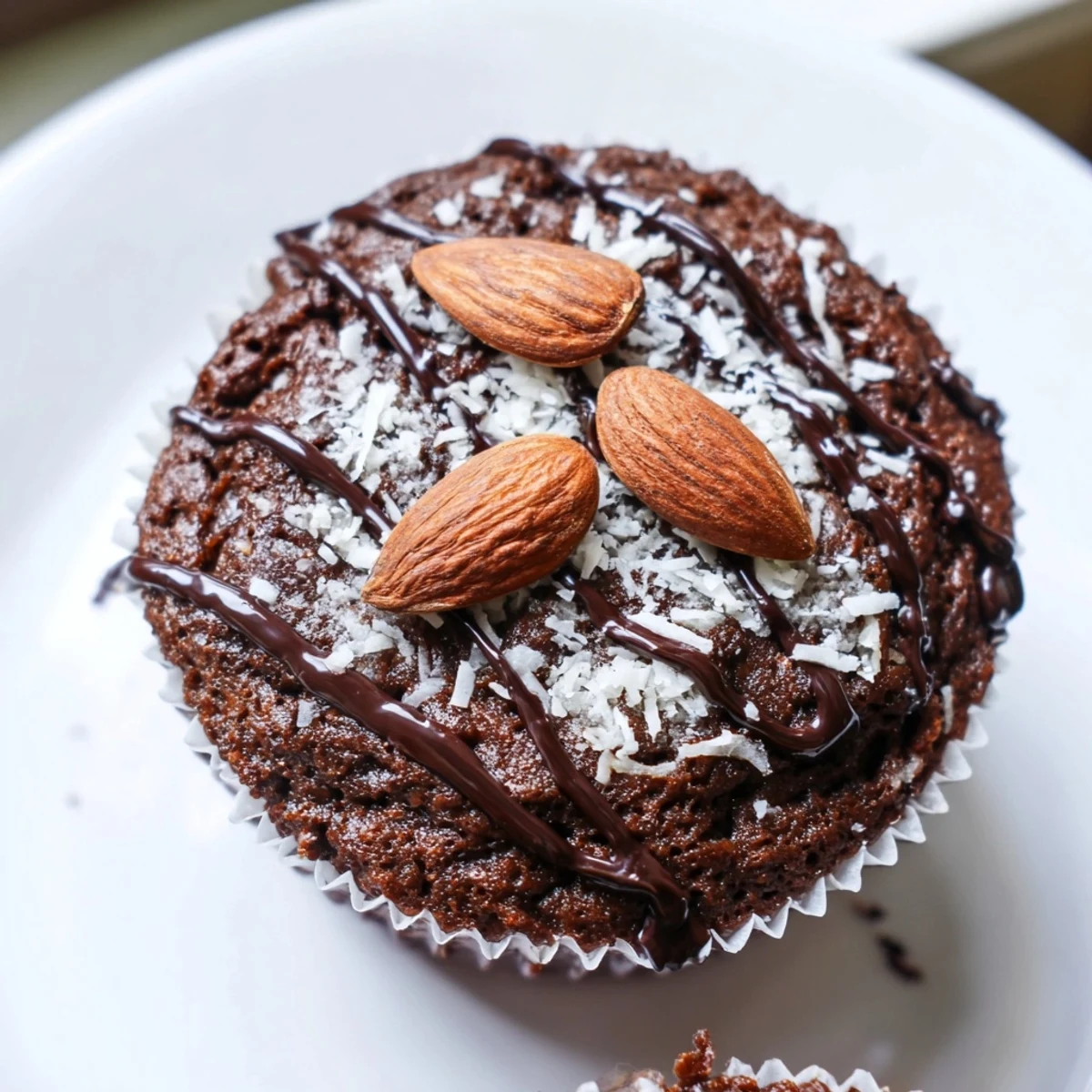 Rich Flourless Almond Joy Cupcakes topped with toasted almonds and a chocolate drizzle