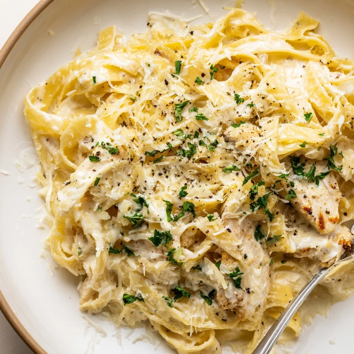 Sliced Creamy Garlic Chicken Pasta tossed with al dente linguine and parsley