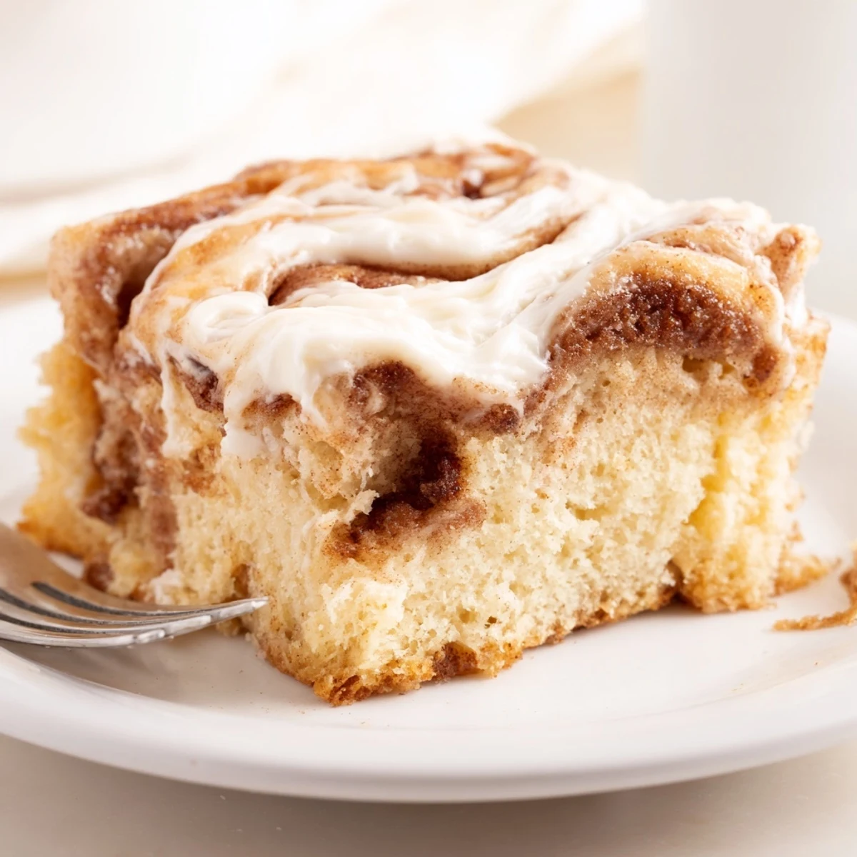 Cinnamon Roll Poke Cake with gooey cinnamon pockets and cream cheese frosting.