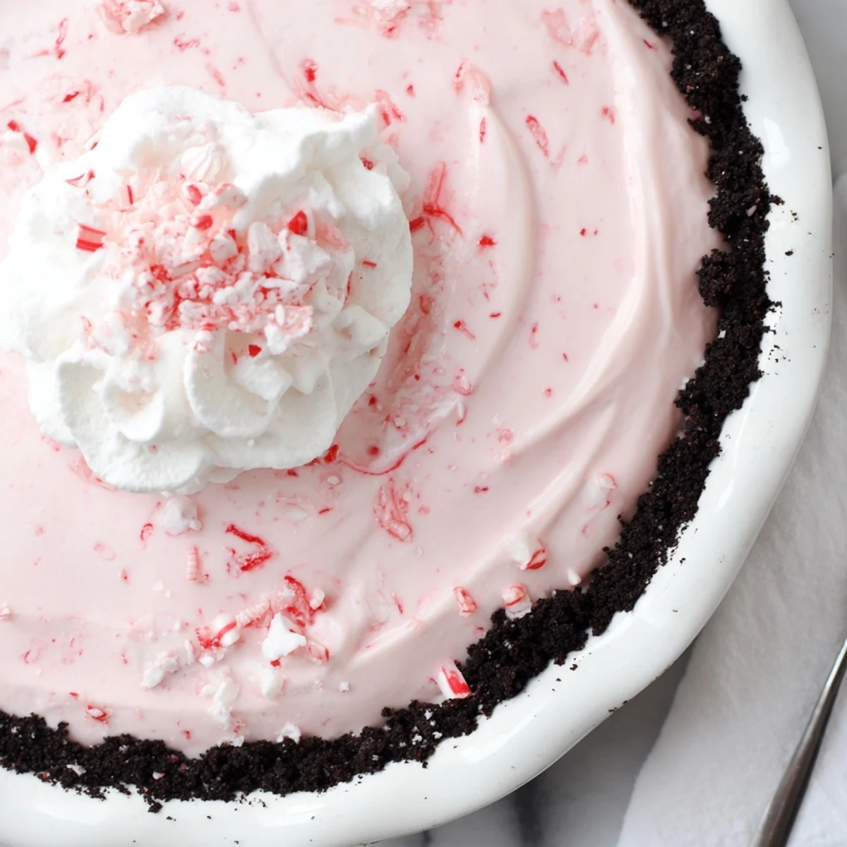 Candy Cane Pie chilled in a chocolate crust, creamy peppermint and crunch
