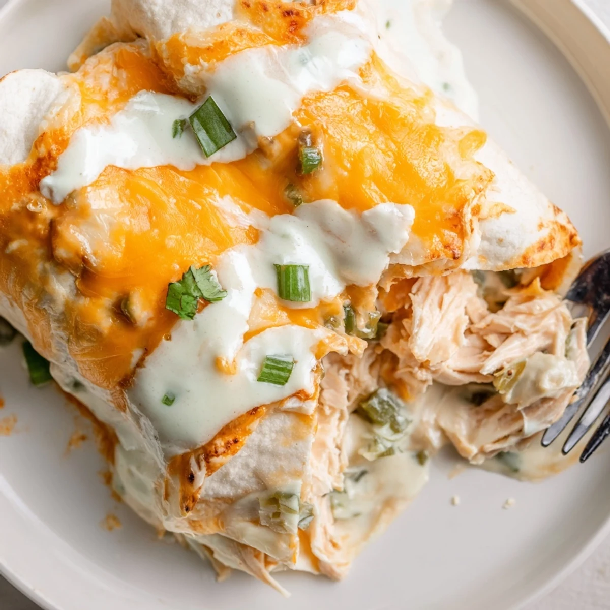 Creamy White Rotisserie Chicken Enchiladas bubbling in a baking dish, cheese melting