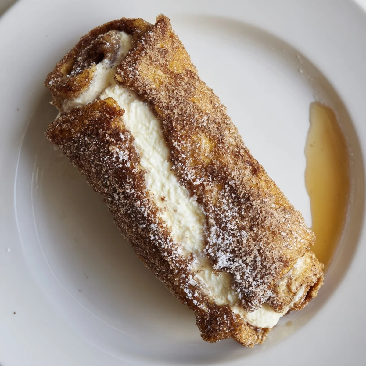 Cinnamon Roll French Toast Roll Ups sliced, gooey cream cheese oozing, served warm