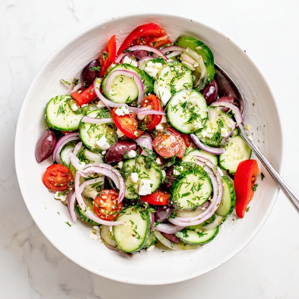 Vibrant bowl of Mediterranean cucumber salad featuring juicy tomatoes and tangy Kalamata olives