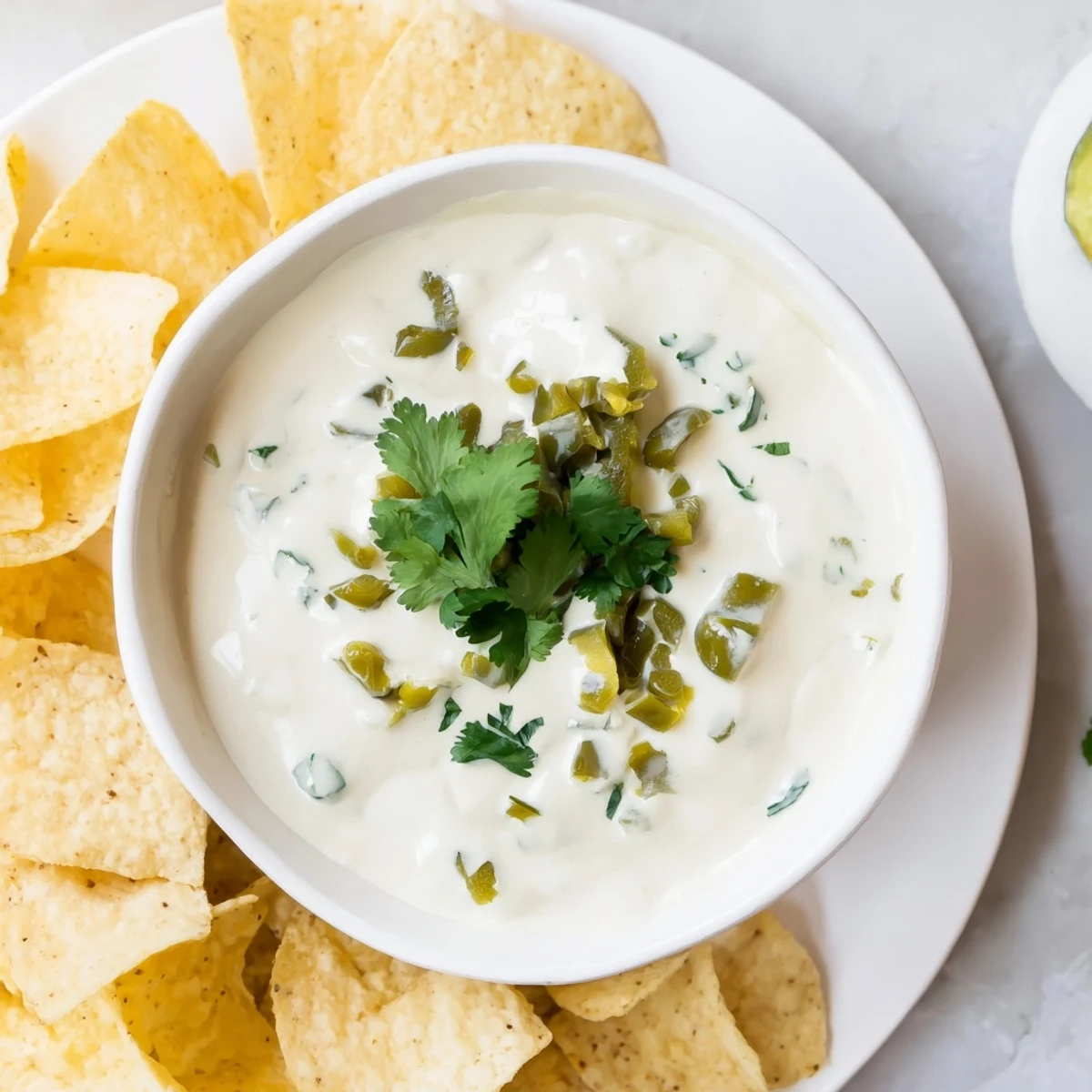 Creamy white Mexican sauce drizzled over crispy tacos with fresh cilantro garnish
