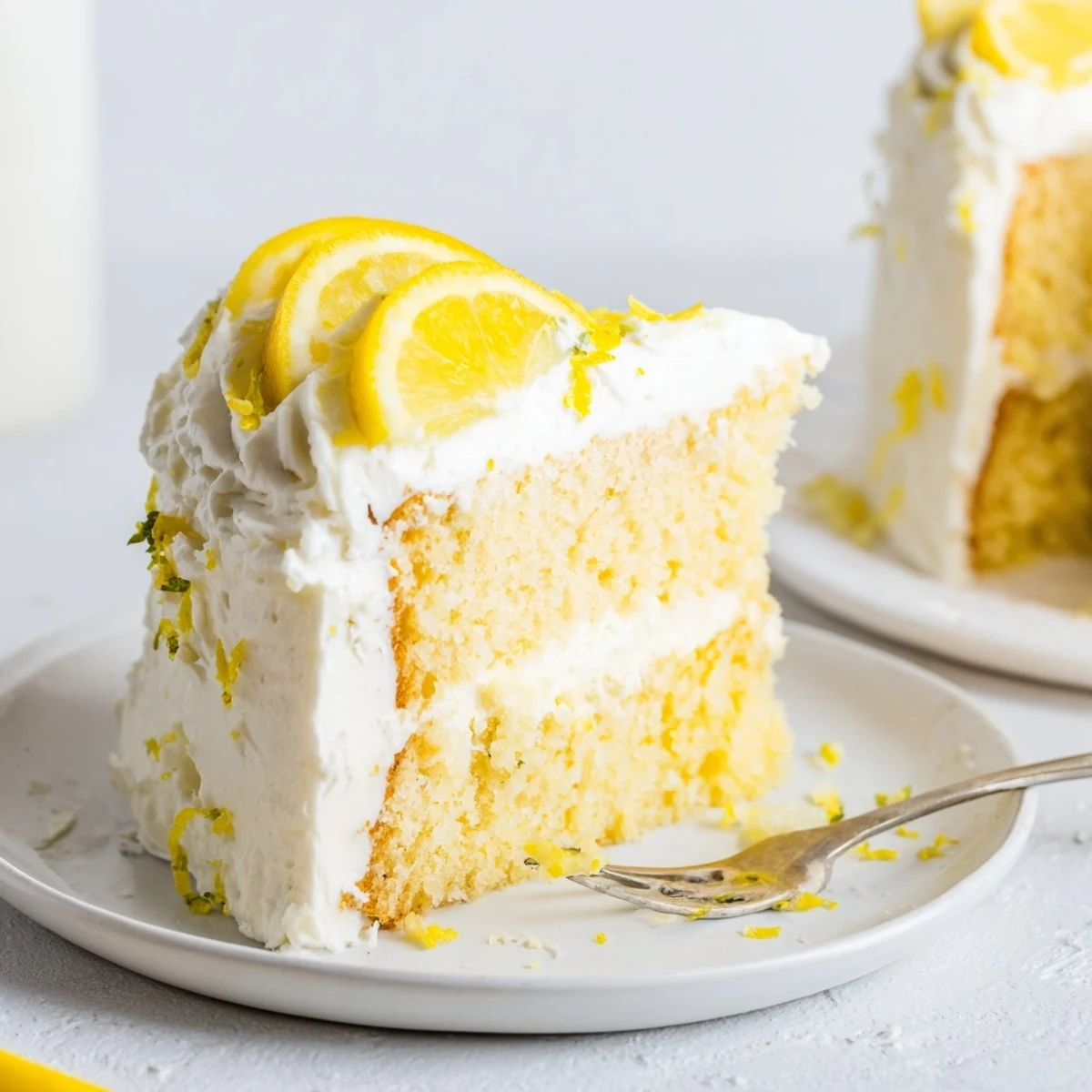 Two-layer lemon birthday cake with fluffy cream cheese frosting and fresh lemon garnish
