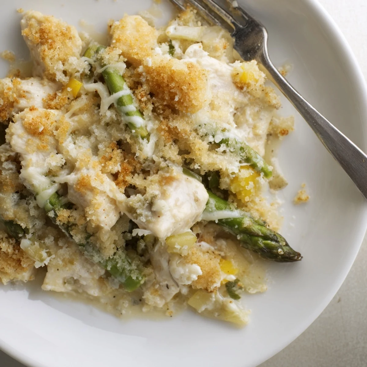 Creamy Chicken Asparagus Bake bubbling with golden cheese, tender chicken, fresh asparagus